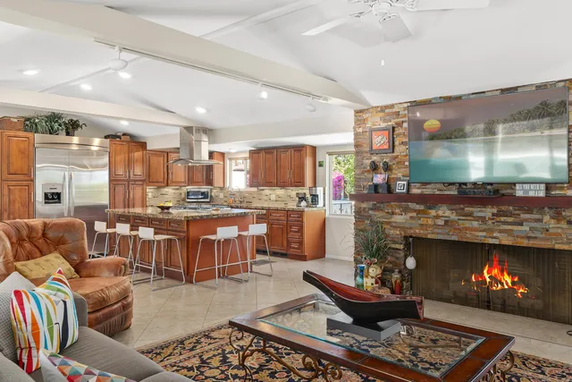 a kitchen with stainless steel appliances granite countertop a stove top oven a sink dishwasher and chairs with wooden cabinets