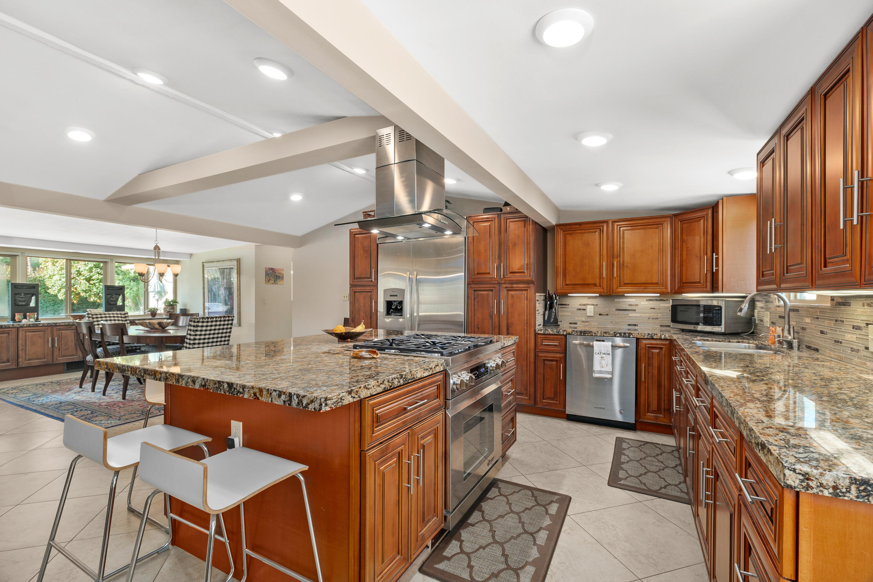 70801 Fairway Drive Rancho Mirage, CA 92270 - Photo 15 of 48 a kitchen with stainless steel appliances granite countertop a stove top oven a sink dishwasher and chairs with wooden cabinets