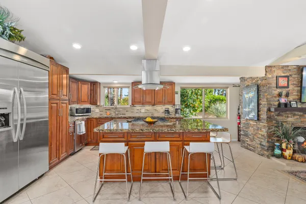 a kitchen with a stove a sink refrigerator and cabinets