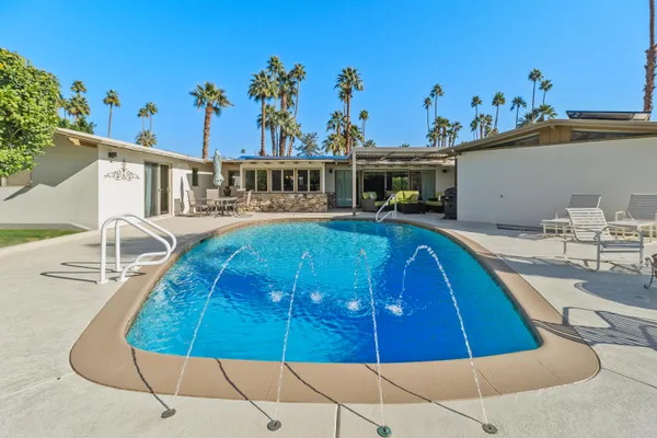 a swimming pool with outdoor seating and yard