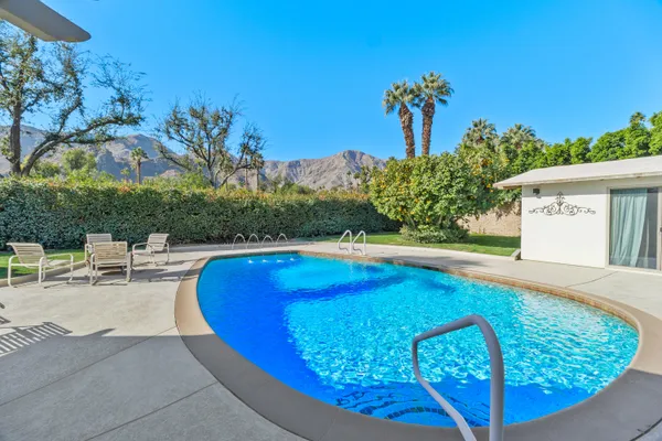 a view of a swimming pool with an outdoor seating and a potted plant