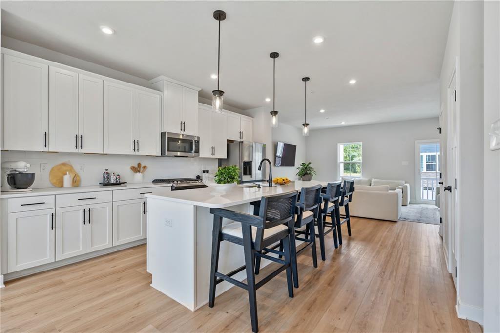4608 Spruce Road Gibsonia, PA 15044 - Photo 5 of 32 a kitchen with stainless steel appliances a dining table chairs stove refrigerator and cabinets