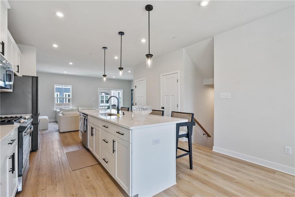 4608 Spruce Road Gibsonia, PA 15044 - Photo 7 of 32 a large kitchen with kitchen island a stove a sink a center island and wooden floor