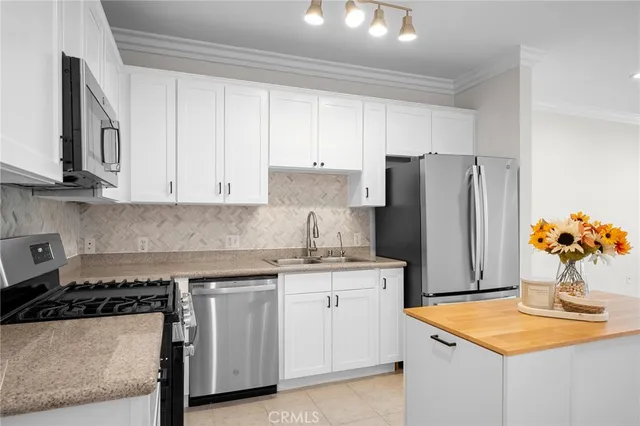 a kitchen with stainless steel appliances granite countertop a refrigerator and a stove