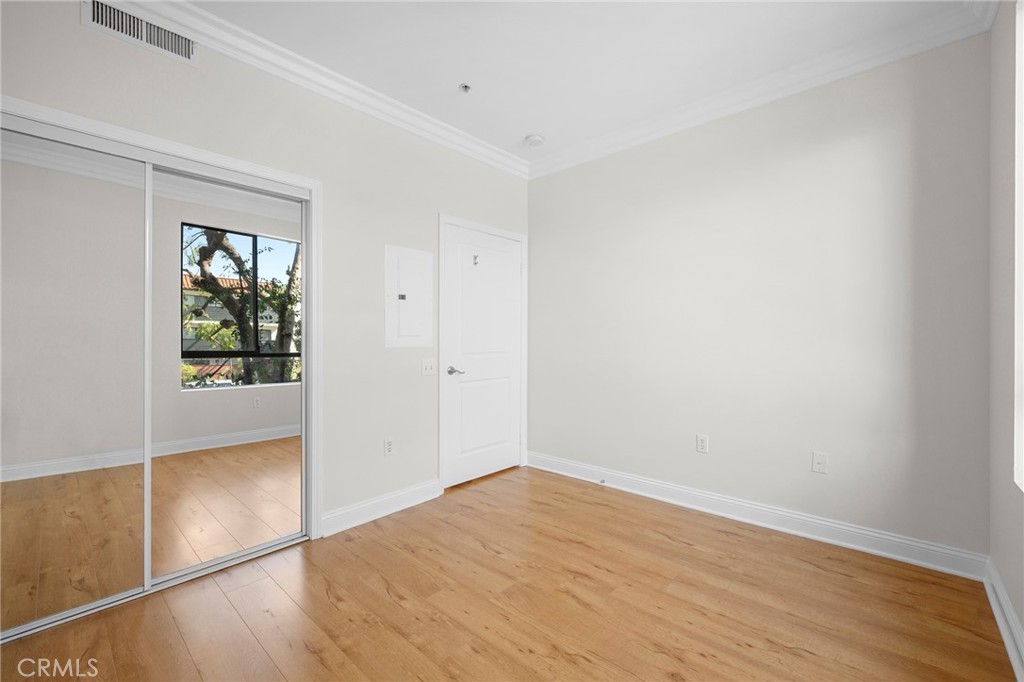6938 Laurel Canyon Boulevard, Unit 101 North Hollywood, CA 91605 - Photo 22 of 32 an empty room with wooden floor and windows