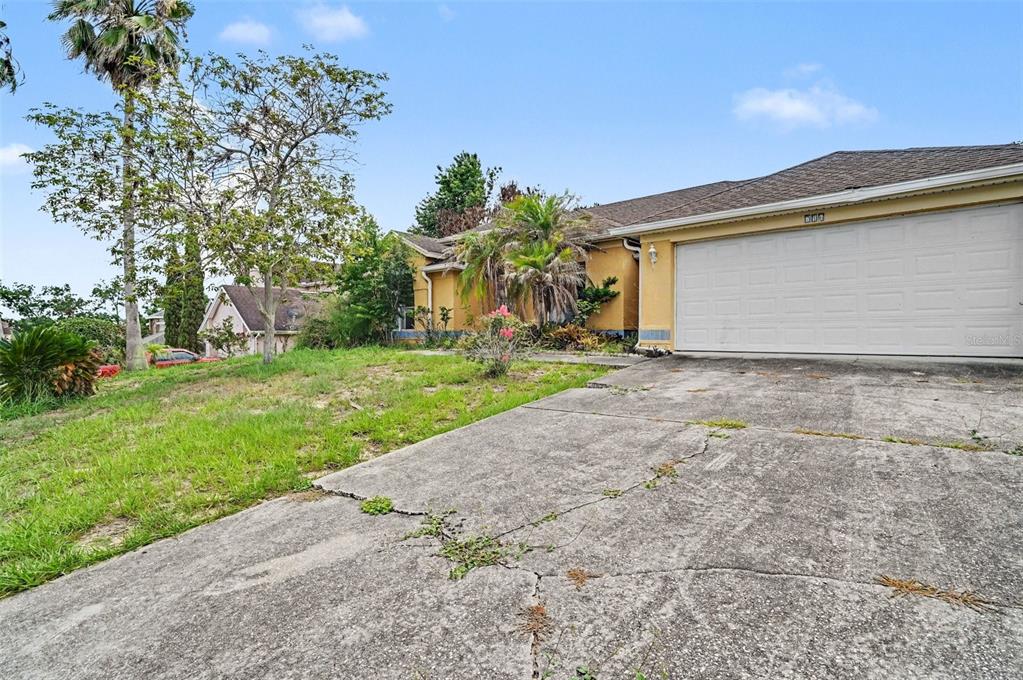 4716 Spaniel Street Orlando, FL 32818 - Photo 3 of 27 a view of a house with a yard and garage
