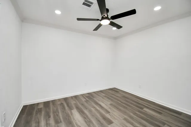 a view of empty room with wooden floor