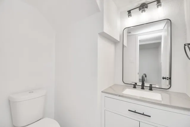 a bathroom with a toilet sink and mirror