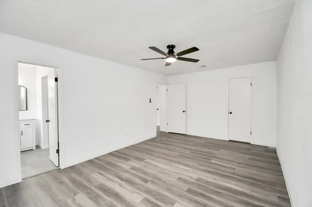 a view of a big room with wooden floor and a ceiling fan