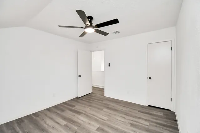 a view of a big room with wooden floor and windows
