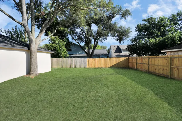 front view of a house with a yard and potted plants