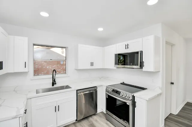 a kitchen with stainless steel appliances a sink a stove and microwave