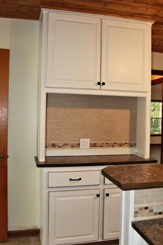 a view of white cabinets and a wooden floor