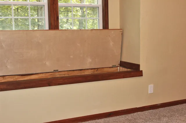 an empty room with a fan & windows