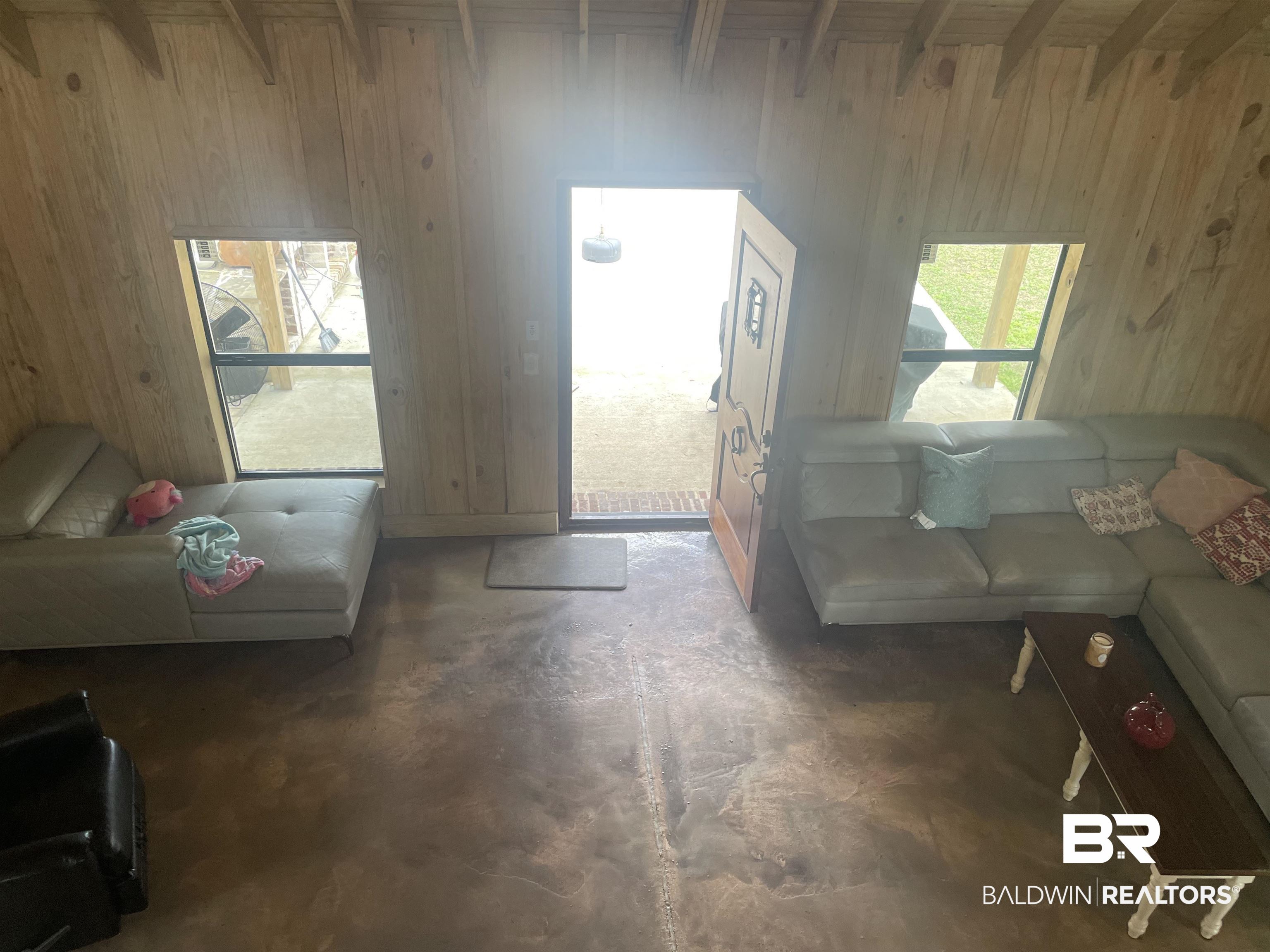 21593 Hubbard Road Robertsdale, AL 36567 - Photo 18 of 22 Living room featuring wood walls and concrete flooring