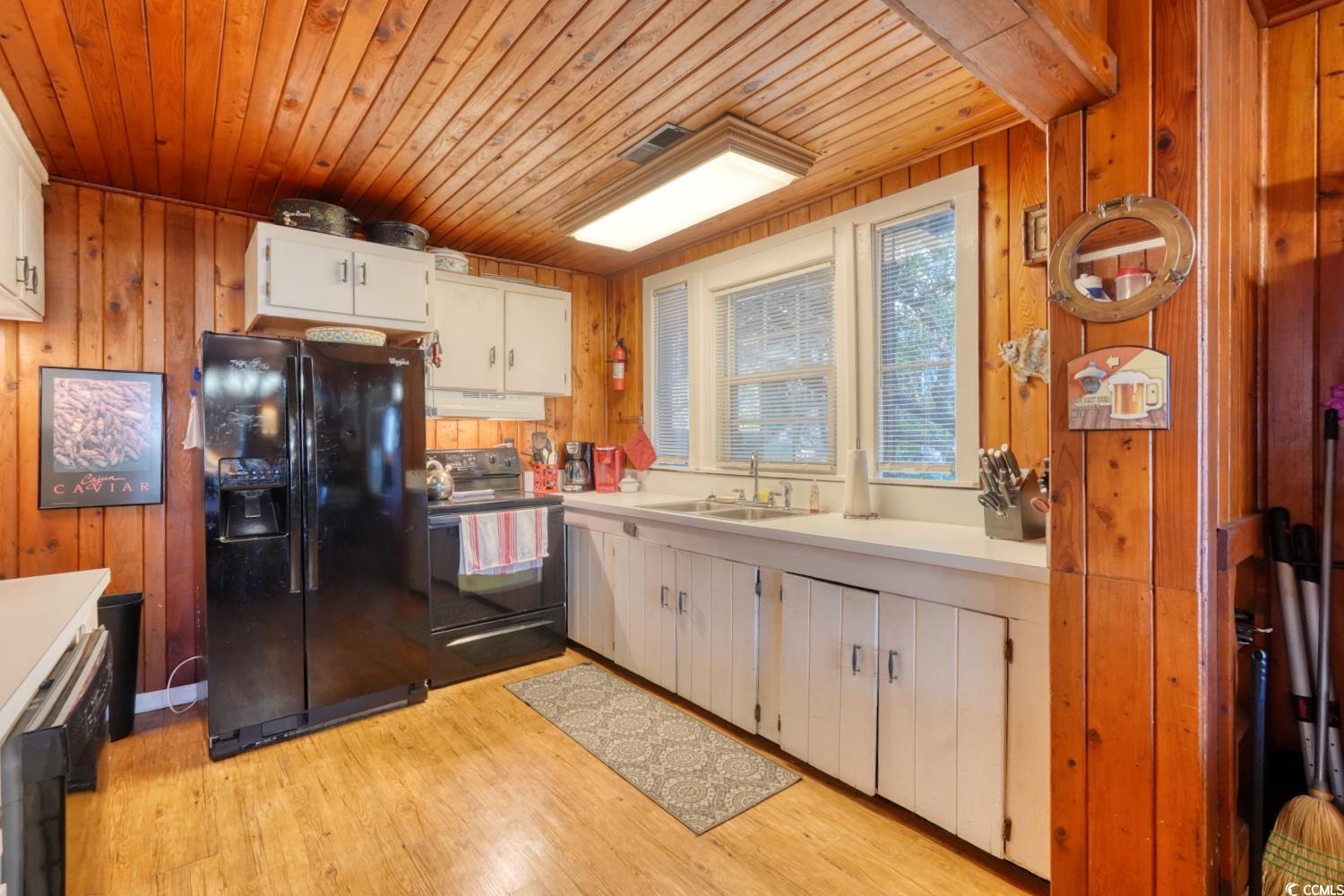350 Underwood Drive Murrells Inlet, SC 29576 - Photo 13 of 36 Kitchen featuring wooden walls, black appliances, light countertops, light wood-style floors, and wood ceiling