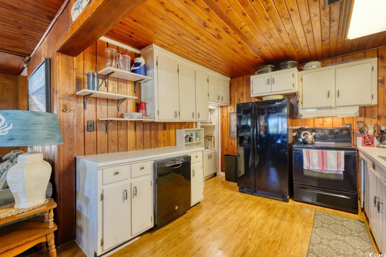 350 Underwood Drive Murrells Inlet, SC 29576 - Photo 14 of 36 Kitchen with open shelves, wood walls, black appliances, wood ceiling, and light countertops