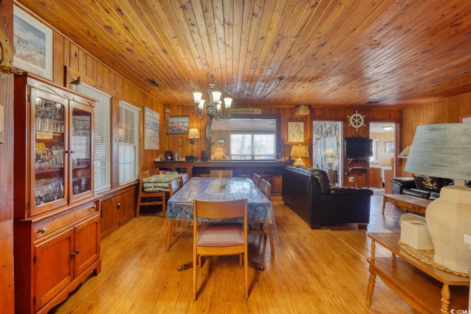 350 Underwood Drive Murrells Inlet, SC 29576 - Photo 15 of 36 Dining room with wood walls, light wood-style flooring, a chandelier, and wooden ceiling