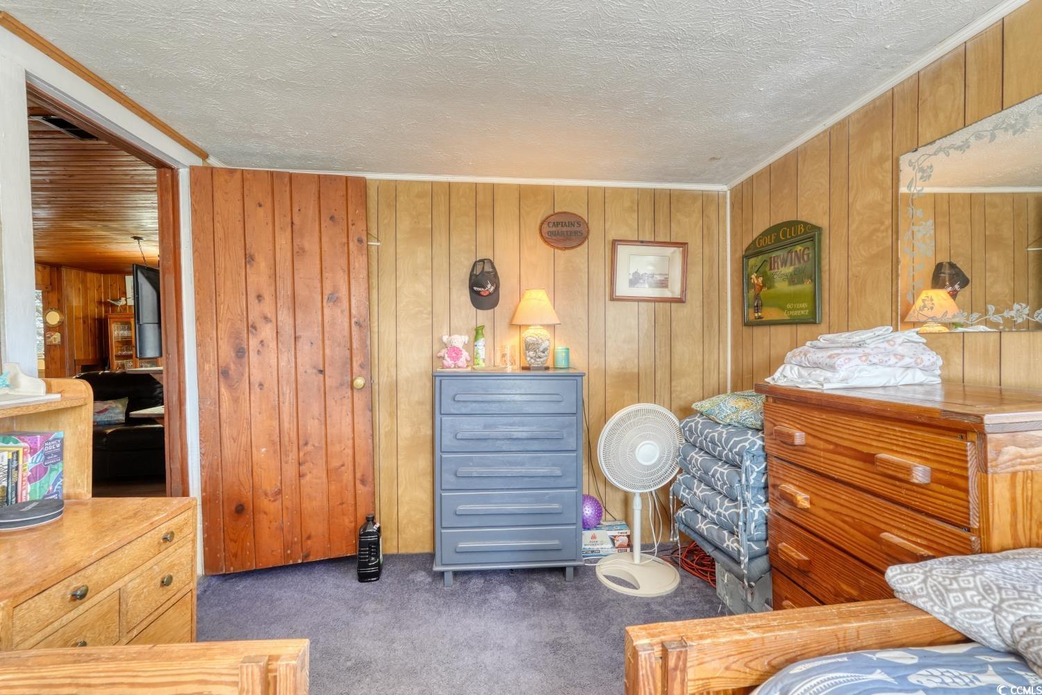 350 Underwood Drive Murrells Inlet, SC 29576 - Photo 21 of 36 Carpeted bedroom featuring wooden walls and a textured ceiling
