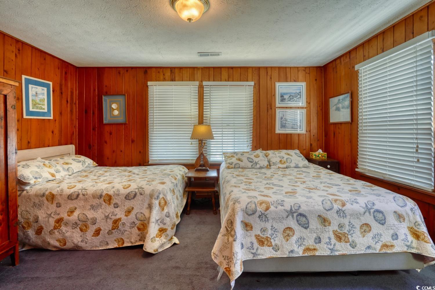 350 Underwood Drive Murrells Inlet, SC 29576 - Photo 29 of 36 Bedroom with wooden walls, dark carpet, and a textured ceiling