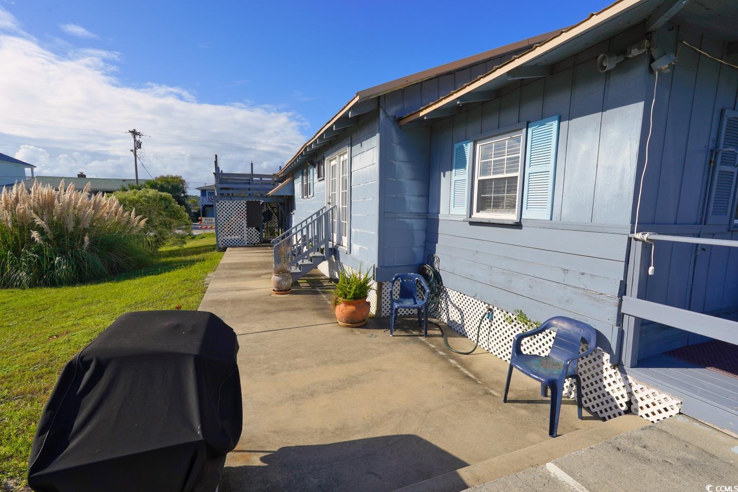 350 Underwood Drive Murrells Inlet, SC 29576 - Photo 34 of 36 View of side of home featuring a lawn, a patio, and board and batten siding