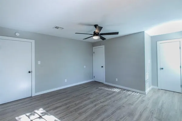 a view of an empty room with wooden floor