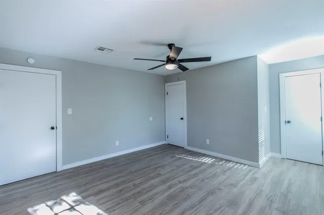 a view of an empty room with wooden floor