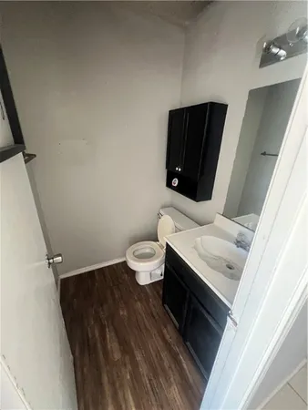 a bathroom with a granite countertop toilet and a sink