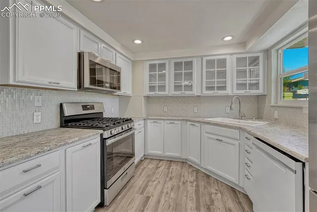 a kitchen with stainless steel appliances granite countertop a stove and a sink
