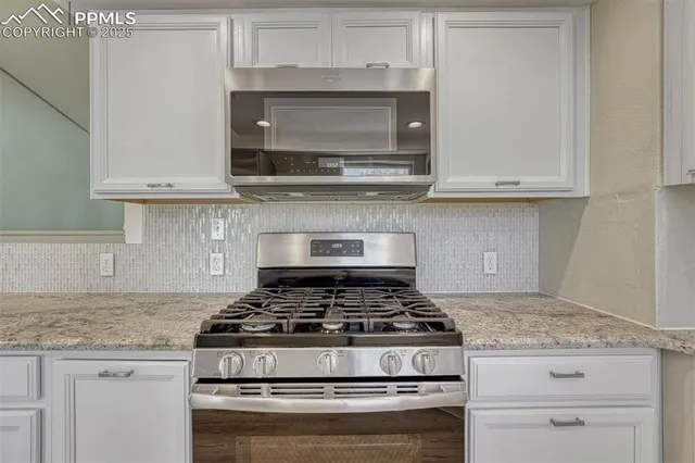 a stove top oven sitting inside of a kitchen and granite counter tops