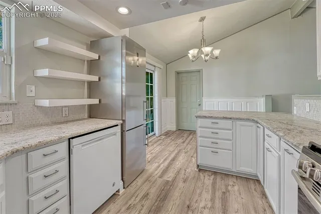 a kitchen with cabinets stainless steel appliances and wooden floor