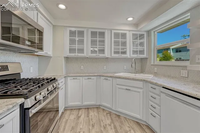 a kitchen with stainless steel appliances granite countertop a stove and a sink