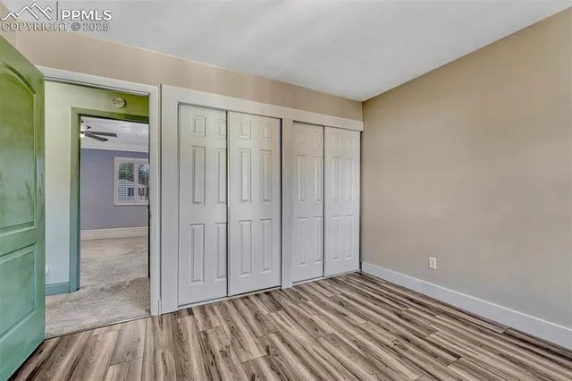 a view of an empty room with closet and a window