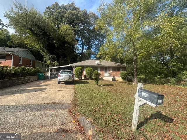 a view of a house with backyard and sitting area