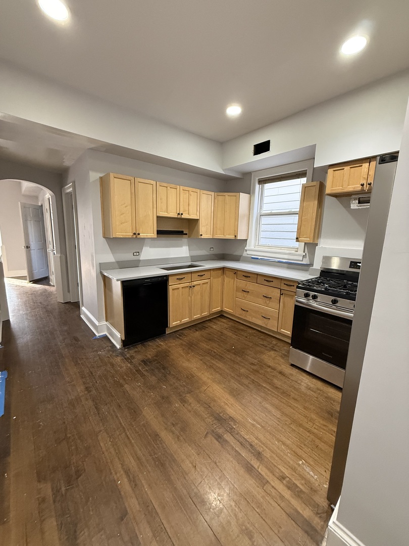 3252 West Crystal Street, Unit 2 Chicago, IL 60651 - Photo 6 of 13 a large kitchen with stainless steel appliances granite countertop a stove and a sink
