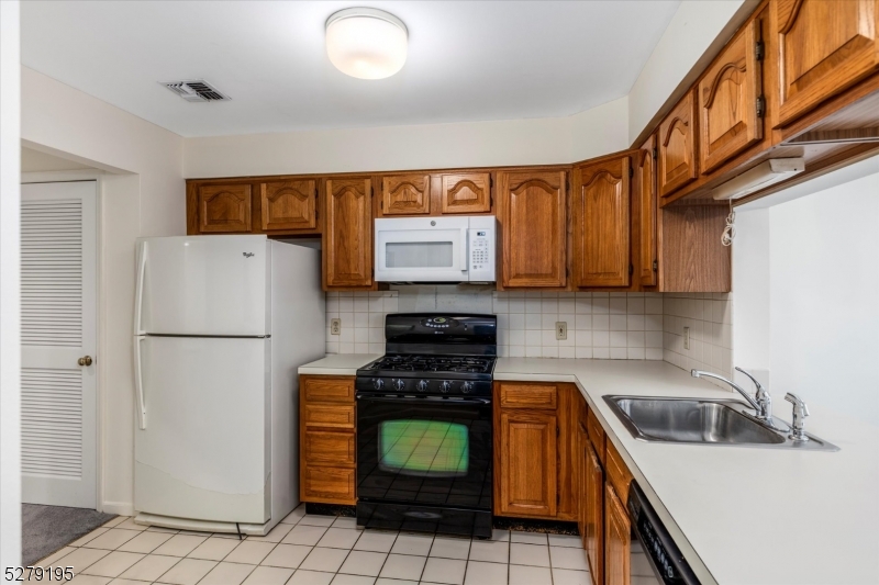 a kitchen with a refrigerator a stove top oven a sink and cabinets