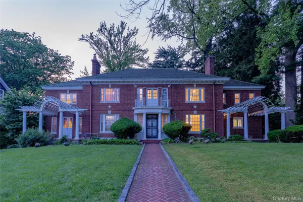 front view of a brick house with a yard