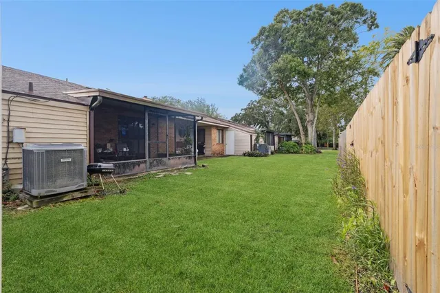 a view of backyard with a garden and a large tree