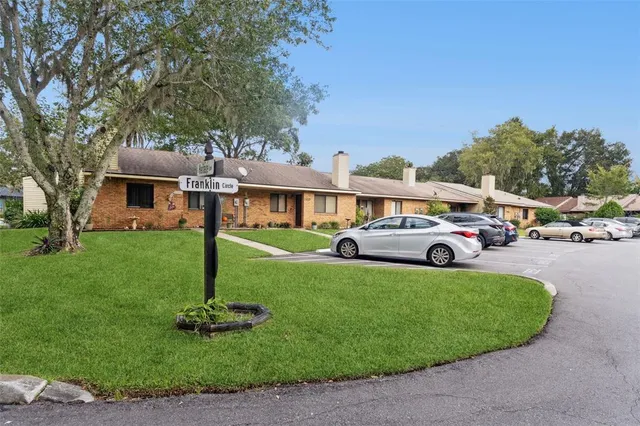 a front view of a house with a garden and trees