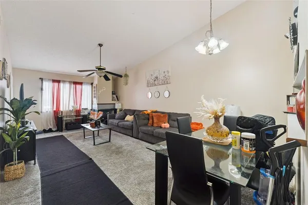 a living room with furniture a chandelier and a dining room