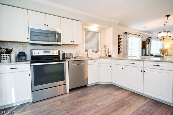 a kitchen with stainless steel appliances white cabinets and a sink