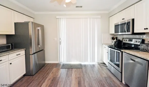 a kitchen with a refrigerator stove and wooden cabinets