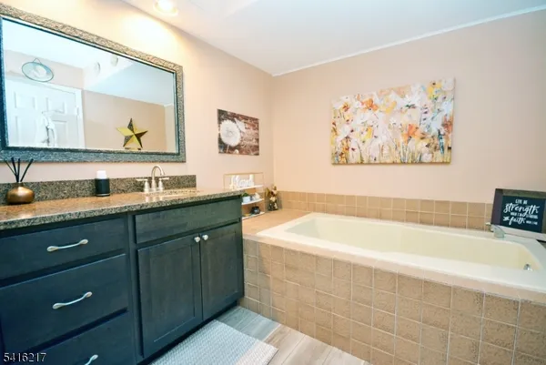 a spacious bathroom with a tub a sink and mirror