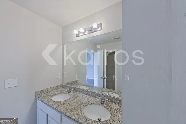 a bathroom with a granite countertop sink a mirror and a light fixture