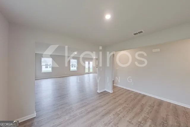 a view of an empty room with wooden floor