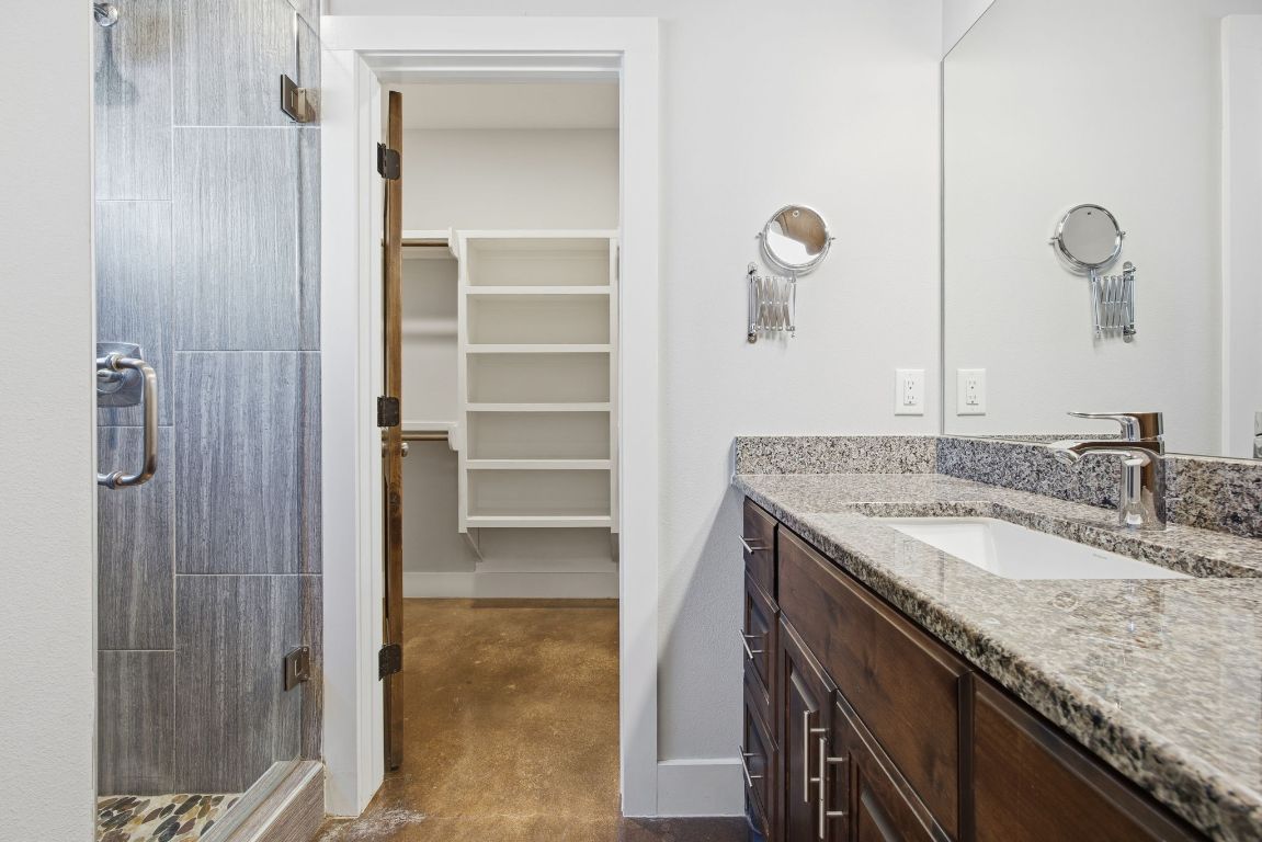 1125 Walton Lane, Unit D Austin, TX 78721 - Photo 17 of 34 a bathroom with a granite countertop sink and a mirror