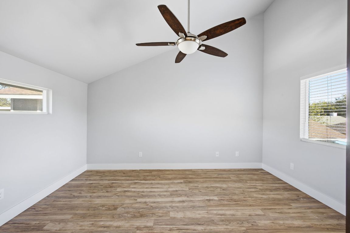 1125 Walton Lane, Unit D Austin, TX 78721 - Photo 21 of 34 a view of an empty room with wooden floor and a window