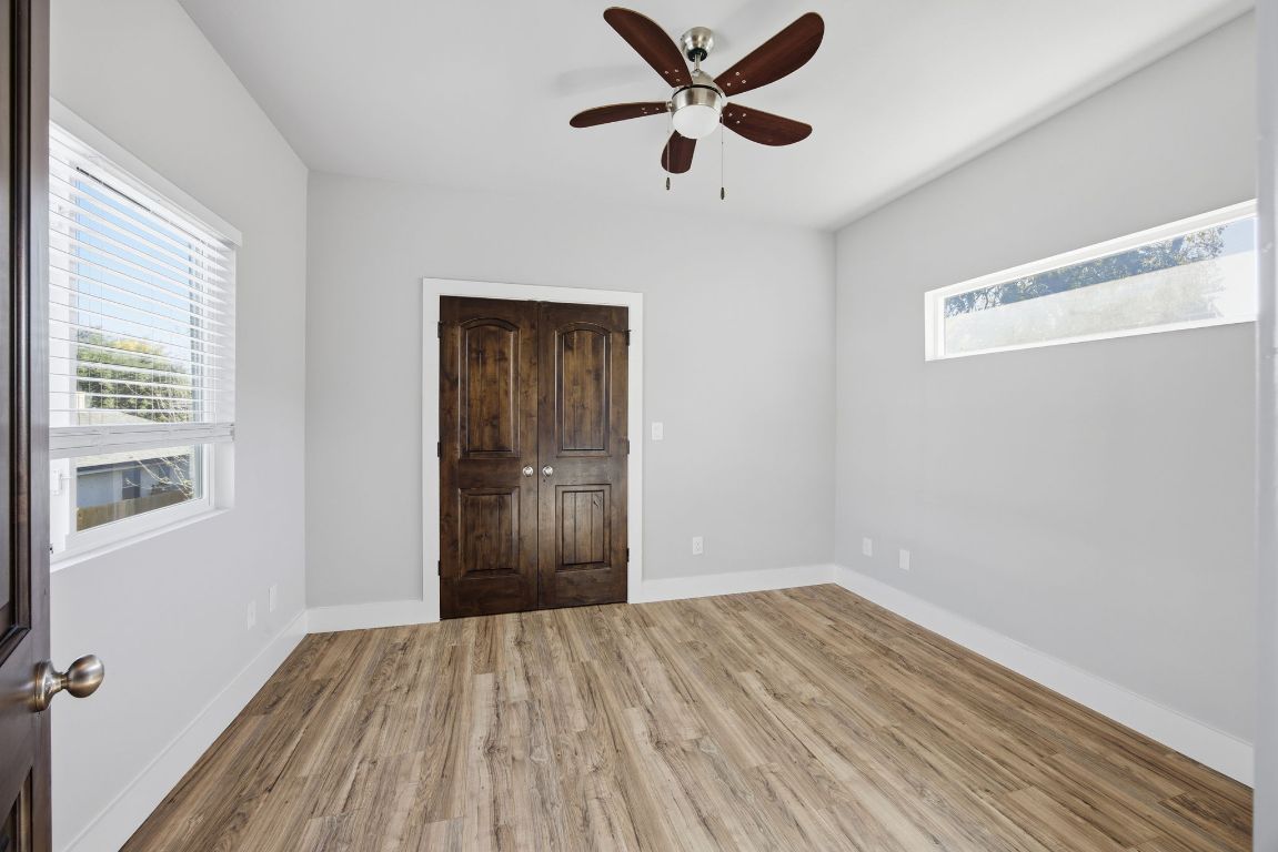 1125 Walton Lane, Unit D Austin, TX 78721 - Photo 28 of 34 a view of a room with wooden floor and a ceiling fan