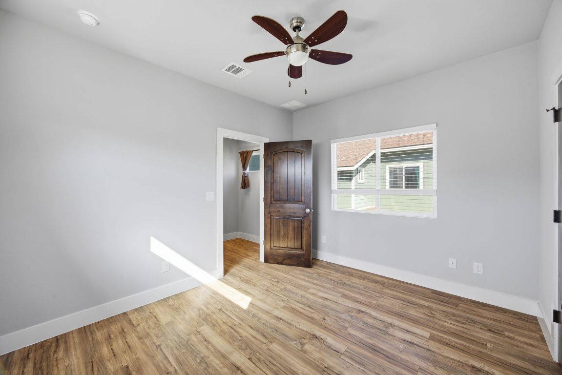 1125 Walton Lane, Unit D Austin, TX 78721 - Photo 29 of 34 a view of empty room with wooden floor and fan