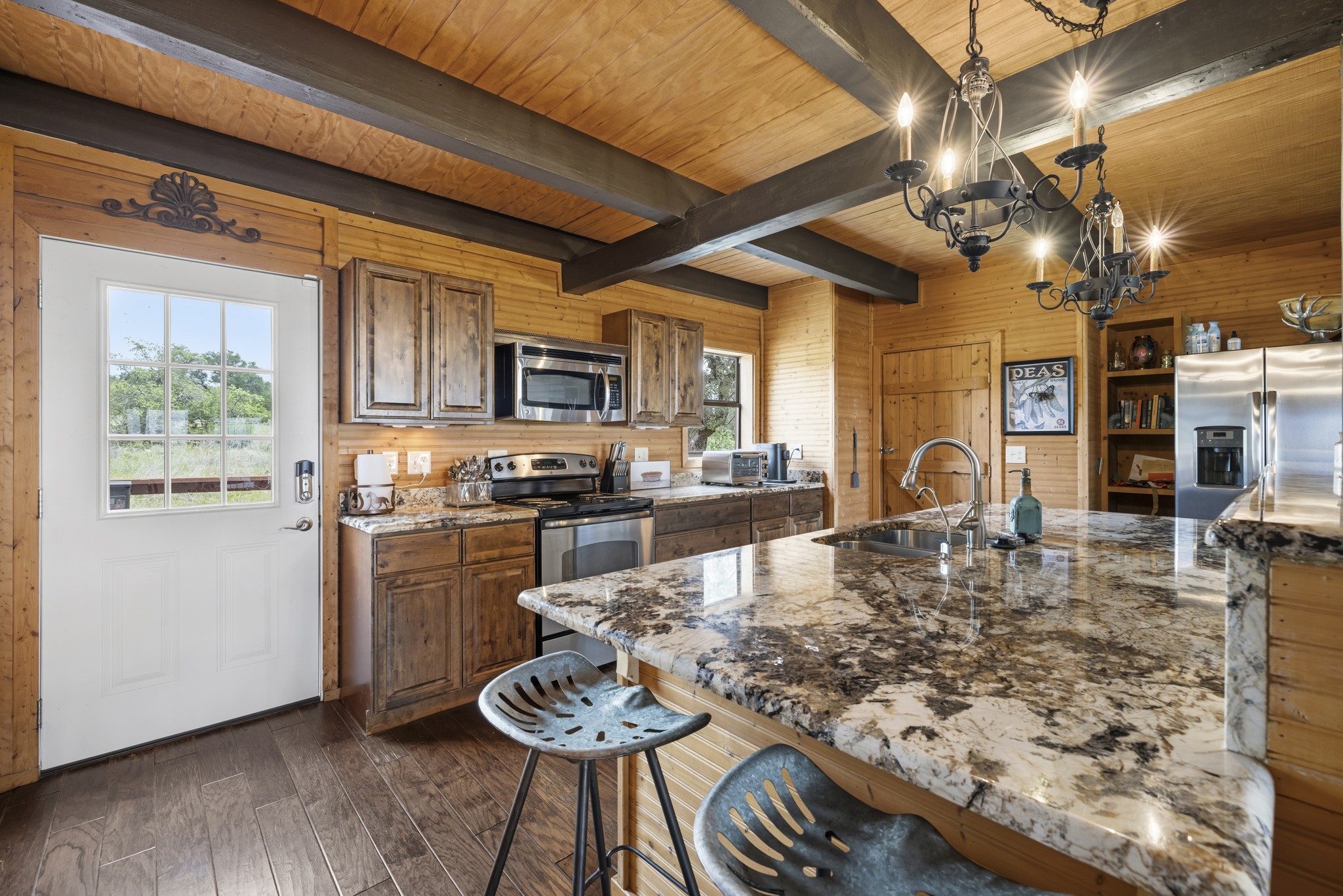 611 Weddle Road Johnson City, TX 78636 - Photo 16 of 30 a kitchen with stainless steel appliances granite countertop a stove a refrigerator a kitchen island a dining table and chairs with wooden floor